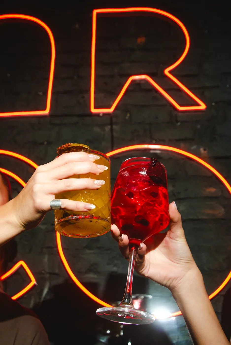 Un brindis frente al cartel de neón de Arco